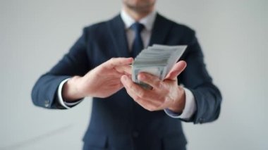 Formally dressed man makes money rain from US dollar bills. Slow motion. Concept of investment, success, financial prospects or career advancement