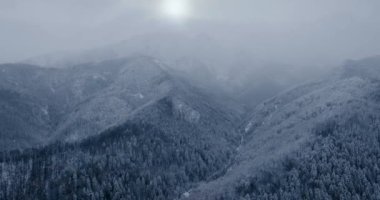 Flight over a fabulous snow-covered mountain landscape. Fairy winter landscape on a frosty gloomy day. Tatra Mountains, Zakopane, Poland