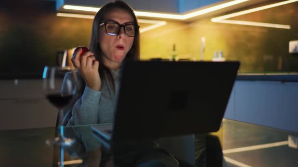 Woman Glasses Sitting Kitchen Working Laptop Night Eating Apple Concept — Video Stock