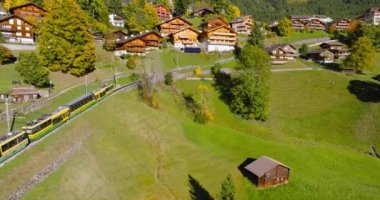 İsviçre 'nin güzel doğası ve Lauterbrunnen köyünün havadan görünüşü, tren, dağ yolunda yavaş ilerliyor. Ünlü İsviçre turizm beldesi.