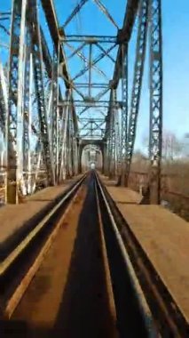 Dikey video. Demiryolu köprüsünden hızlı uçuş. FPV Drone 'da çekiliyor.