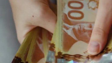Female hands counting Canadian Dollar bills, close-up. Concept of investment, success, financial prospects or career advancement.