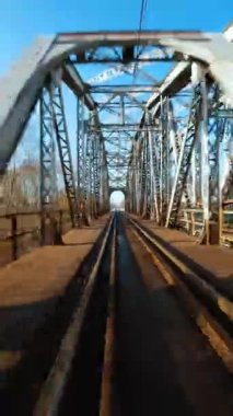 Dikey video. Demiryolu köprüsünden hızlı uçuş. FPV Drone 'da çekiliyor.