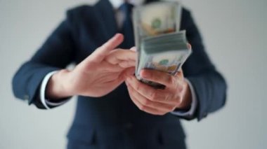 Formally dressed man makes money rain from US dollar bills. Slow motion. Concept of investment, success, financial prospects or career advancement