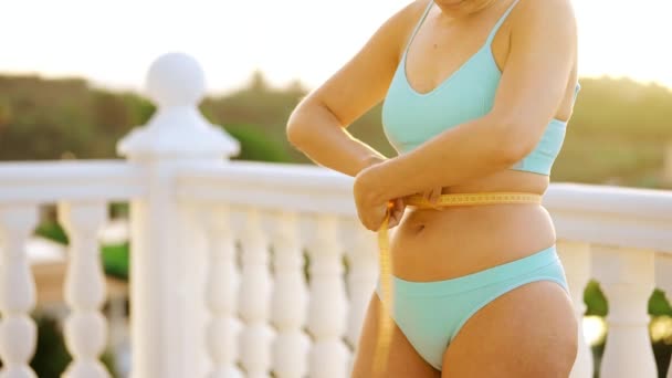 女人在阳台上用测量带测量她的臀部和腰围 然后竖起大拇指 健康饮食结果 — 图库视频影像