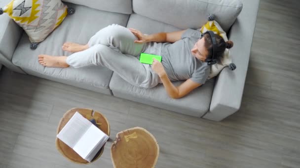 Overhead Shot Relaxed Woman Listening Music Headphones Smartphone Green Mock — Vídeo de Stock