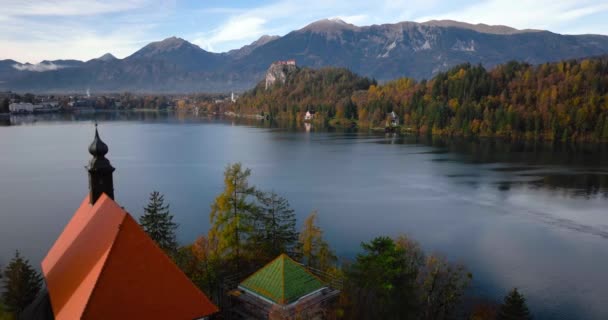 空中からの湖の眺めスロベニアの真ん中にある島と島 湖の聖母マリアの仮定の巡礼教会 — ストック動画