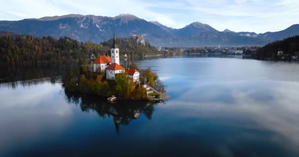 从空中俯瞰布莱德湖及其中央的斯洛文尼亚岛 圣母玛利亚在布莱德湖中的朝圣教堂 — 图库视频影像