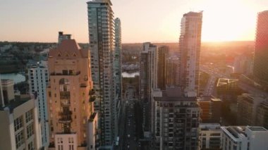 Flight along the street between skyscrapers at sunset. Downtown of Vancouver, British Columbia, Canada.