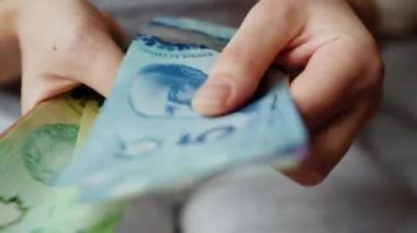 Female hands counting Canadian Dollar bills, close-up. Concept of investment, success, financial prospects or career advancement.
