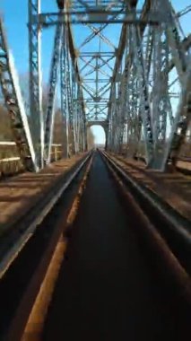 Dikey video. Demiryolu köprüsünden hızlı uçuş. FPV Drone 'da çekiliyor.