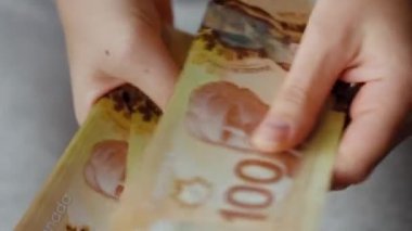 Female hands counting Canadian Dollar bills, close-up. Concept of investment, success, financial prospects or career advancement.