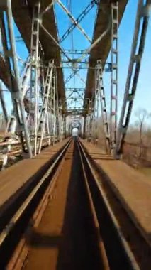 Dikey video. Demiryolu köprüsünden hızlı uçuş. FPV Drone 'da çekiliyor.