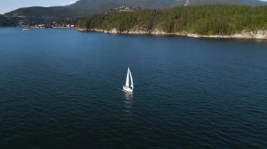 Gün batımında sahil boyunca seyreden bir teknenin hava yörüngesi görüntüsü.. 