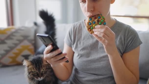 Woman Eating Colorful Chip Cookie Using Smartphone Same Time Unhealthy — Stock Video