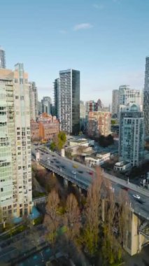Dikey video. Vancouver şehir merkezindeki gökdelenlerin hava görüntüsü ve Granville köprüsündeki trafik, British Columbia, Kanada. 