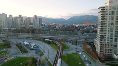 Vancouver şehrinin hava manzarası - şehir merkezi, gökdelenler, yol trafiği, trenler ve arka planda dağlar, British Columbia, Kanada.