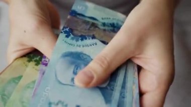 Female hands counting Canadian Dollar bills, close-up. Concept of investment, success, financial prospects or career advancement.
