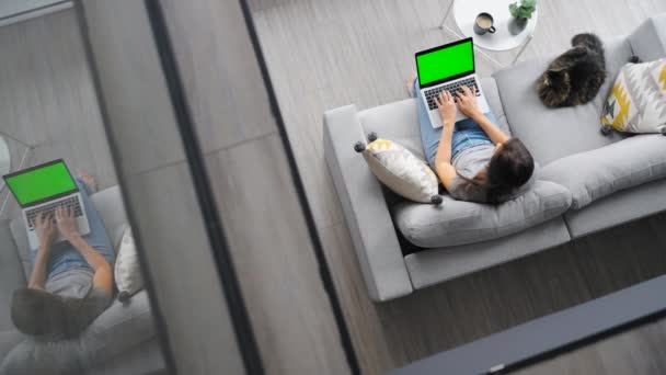 Фотография Женщины Использующей Ноутбук Зеленым Макетом Экрана Сидящей Дома Диване — стоковое видео