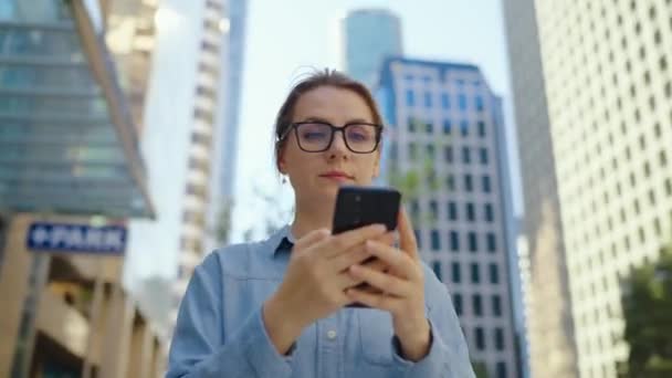 Vit Kvinna Glasögon Som Går Runt Staden Och Använder Smartphone — Stockvideo