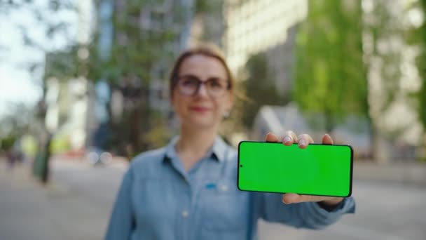 Γυναίκα Γυαλιά Στέκεται Στο Δρόμο Της Πόλης Και Δείχνει Smartphone — Αρχείο Βίντεο