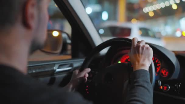 Mannen Som Kör Bil Genom Gatorna Nattstaden Titta Genom Fönstret — Stockvideo