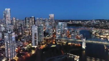 Geceleri Vancouver 'ın merkezindeki Granville Köprüsü ve False Creek' in göz kamaştırıcı hava manzarası. British Columbia, Kanada. Hızlandırılmış video.