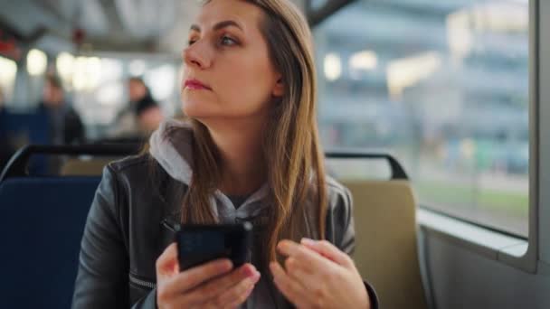 公共交通機関だ スマートフォンのチャットや友人とのテキストメッセージを使用して路面電車の中で女性 スローモーション — ストック動画