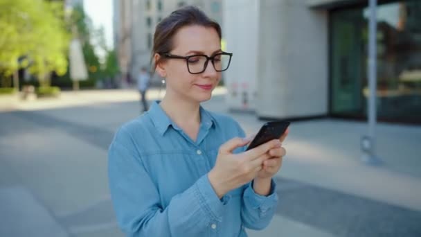 Mujer Caucásica Gafas Caminando Por Ciudad Usando Smartphone Los Rascacielos — Vídeos de Stock