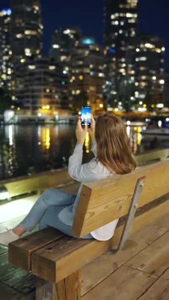 Dikey Video Kadın Gece Akıllı Telefonuyla Vancouver Gökdelenlerinin Fotoğraflarını Çekiyor — Stok video