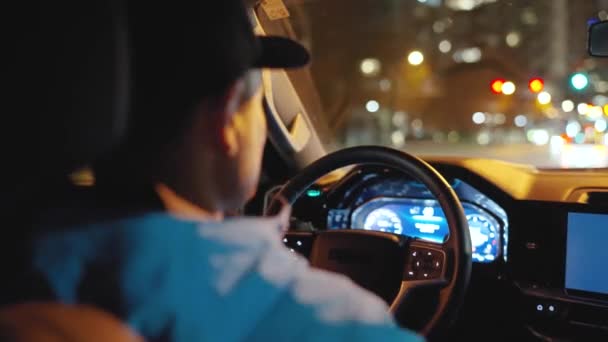 男の夜の街の通りを車で運転 車の窓にグレア 車の後部座席からの眺め — ストック動画