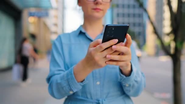 Běloška Brýlích Chodí Městě Používá Smartphone Mrakodrapy Jsou Pozadí Komunikace — Stock video