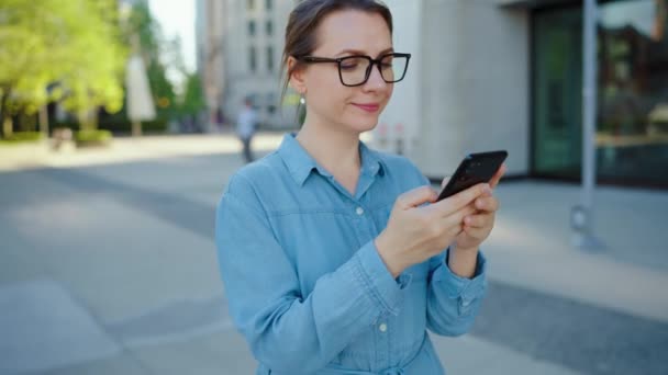 Biała Kobieta Okularach Chodząca Mieście Używająca Smartfona Zwolnione Tempo Drapacze — Wideo stockowe
