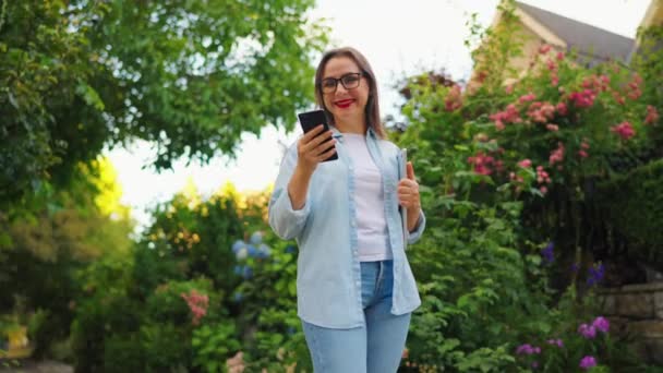 Szczęśliwa Kobieta Laptopem Smartfonem Rękach Stojących Kwitnącym Ogrodzie Lub Zielonej — Wideo stockowe