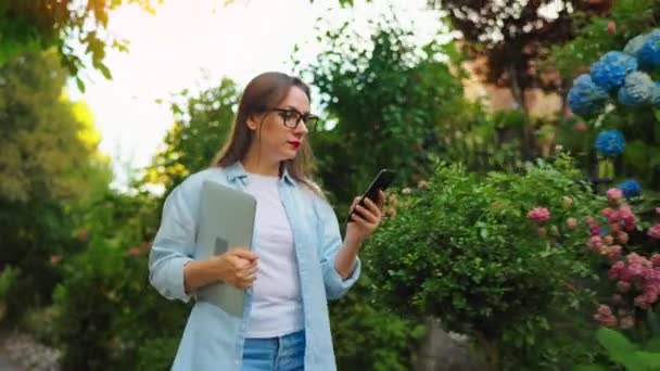 Happy Woman Laptop Smartphone Her Hands Walking Blooming Garden Green — Stock Video