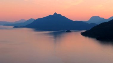 Akşamları Vancouver 'ın kuzeyindeki deniz manzarası. Pembe gökyüzü ve dağların siluetleri. British Columbia, Kanada.