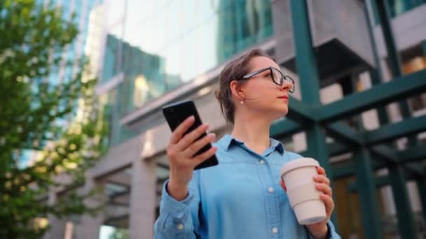 Biała Kobieta Okularach Stoi Ulicy Używając Smartfona Pijąc Kawę Zwolniony — Wideo stockowe