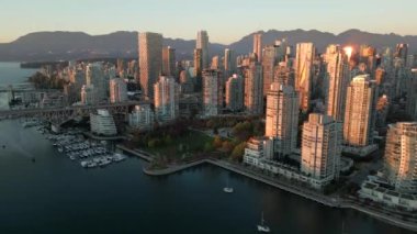 Şehir merkezindeki gökdelenlerin havadan görünüşü, Vancouver, British Columbia, Kanada 'nın dağları ve limanı gün batımında.