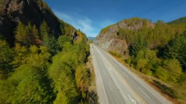 FPV İHA 'sıyla dağ manzarası ve yol üzerinde manevra yapılabilir uçuş. Kanada 'yı dolaş. Vancouver, British Columbia, Kanada yakınlarında çekilmiş.. 
