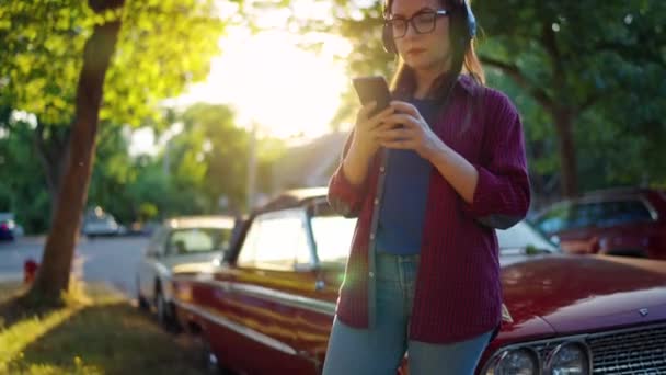 Kulaklık Takan Kadın Dışarıda Kırmızı Vintage Arabanın Yanında Duruyor Yaz — Stok video
