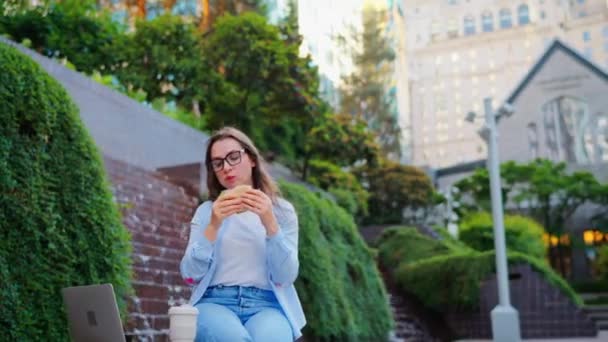 노트북과 공원에 앉아있는 샌드위치와 커피와 점심을하는 코카서스 야외에서요 프리랜서 그녀의 — 비디오