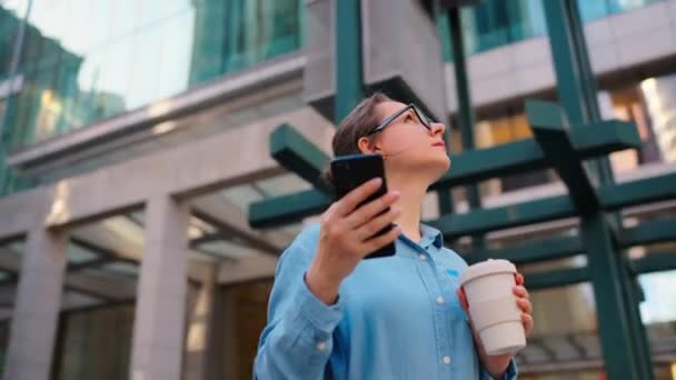 Vit Kvinna Glasögon Står Gatan Använder Smartphone Och Dricker Kaffe — Stockvideo