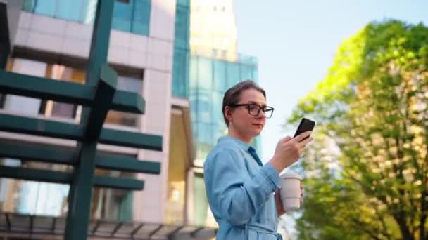 Blanke Vrouw Met Bril Staat Straat Met Behulp Van Smartphone — Stockvideo