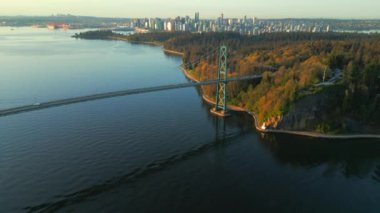 Şafakta Lions Gate Köprüsü ve Stanley Parkı 'nın havadan görüntüsü. Arka planda Vancouver şehir merkezi var. Britanya Kolombiyası Kanada.