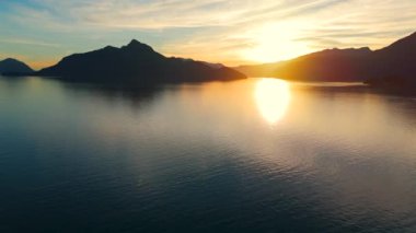 Vancouver 'ın kuzeyindeki güzel günbatımında deniz manzarası. Dağların siluetlerinin üzerine güneş batıyor. British Columbia, Kanada.