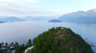 Akşamları Vancouver 'ın kuzeyindeki deniz manzarası. Mavi bulutlu gökyüzü ve dağların siluetleri. British Columbia, Kanada.