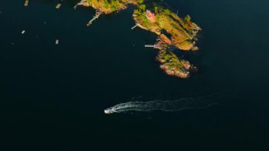 Adanın sahil şeridinde motorlu tekne manzarası var. Drone 'dan deniz burnu. Kameralar dönüyor. Seyahat videosu