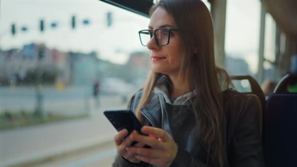 公共交通機関だ スマートフォンのチャットや友人とのテキストメッセージを使用して路面電車の中で女性 スローモーション — ストック動画