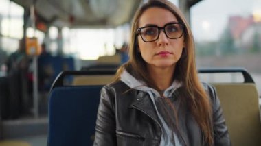 Public transport. Woman in glasses riding a tram in the city. City, urban, transportation.