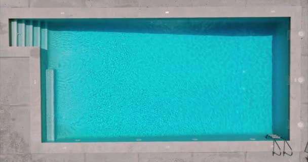 光の反射 スローモーションとスイミングプールで純粋な青い水の表面 空中映像 — ストック動画